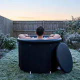 A person sitting upright in the Ice Bath Tub, water up to the shoulders